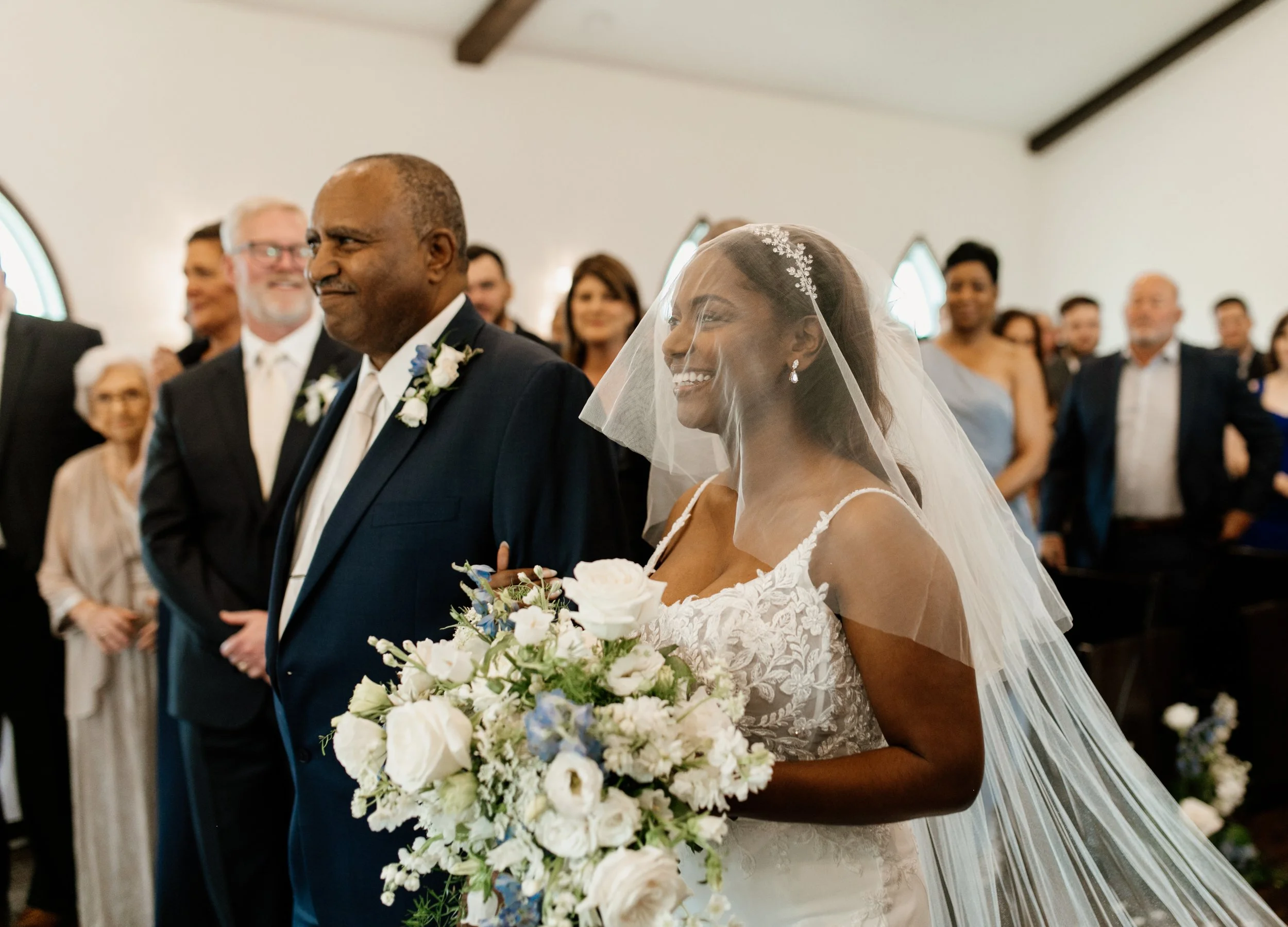 Bride and groom walking, laughing with their wedding party