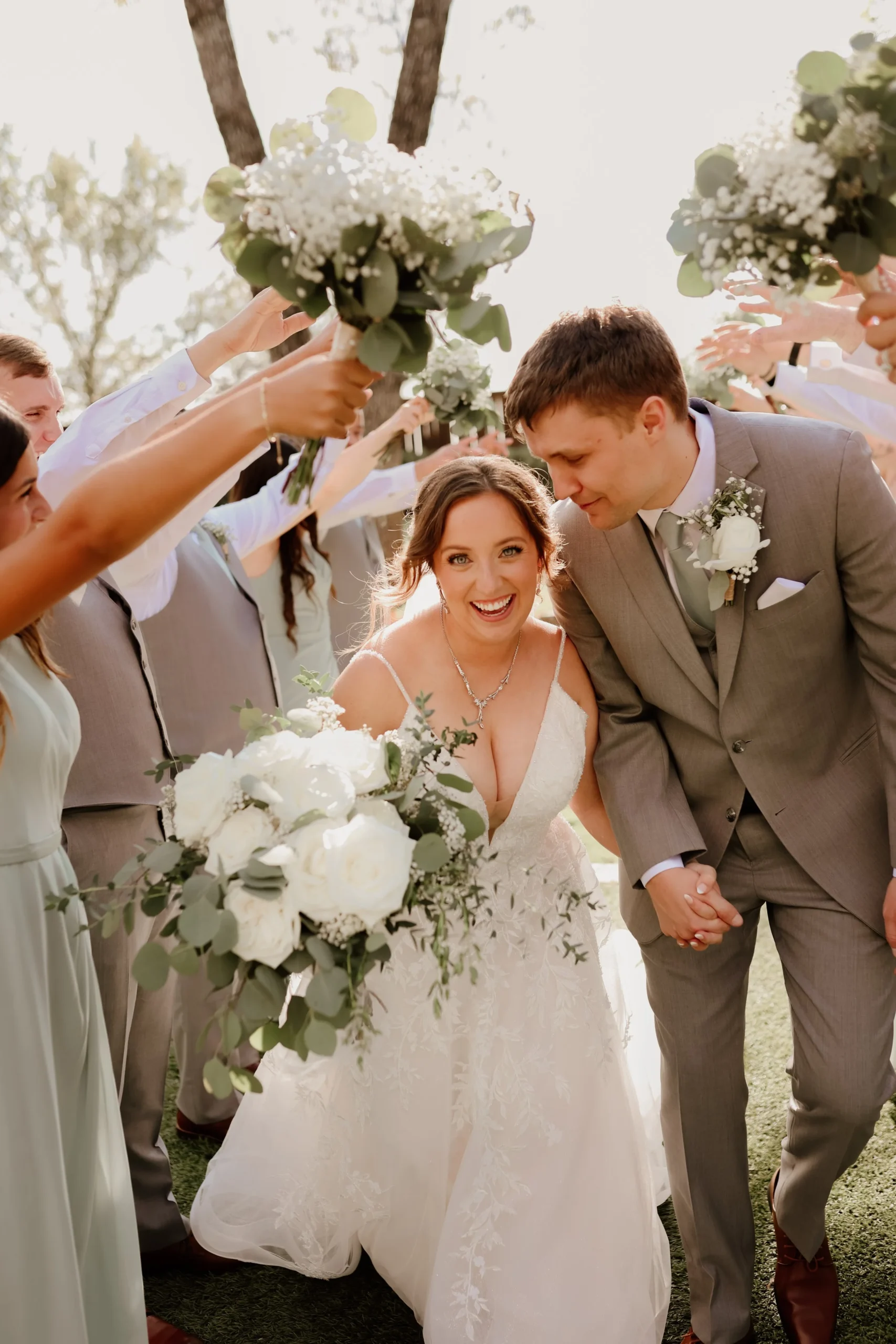 Bride and Groom walking through a fun tunnel of their wedding party