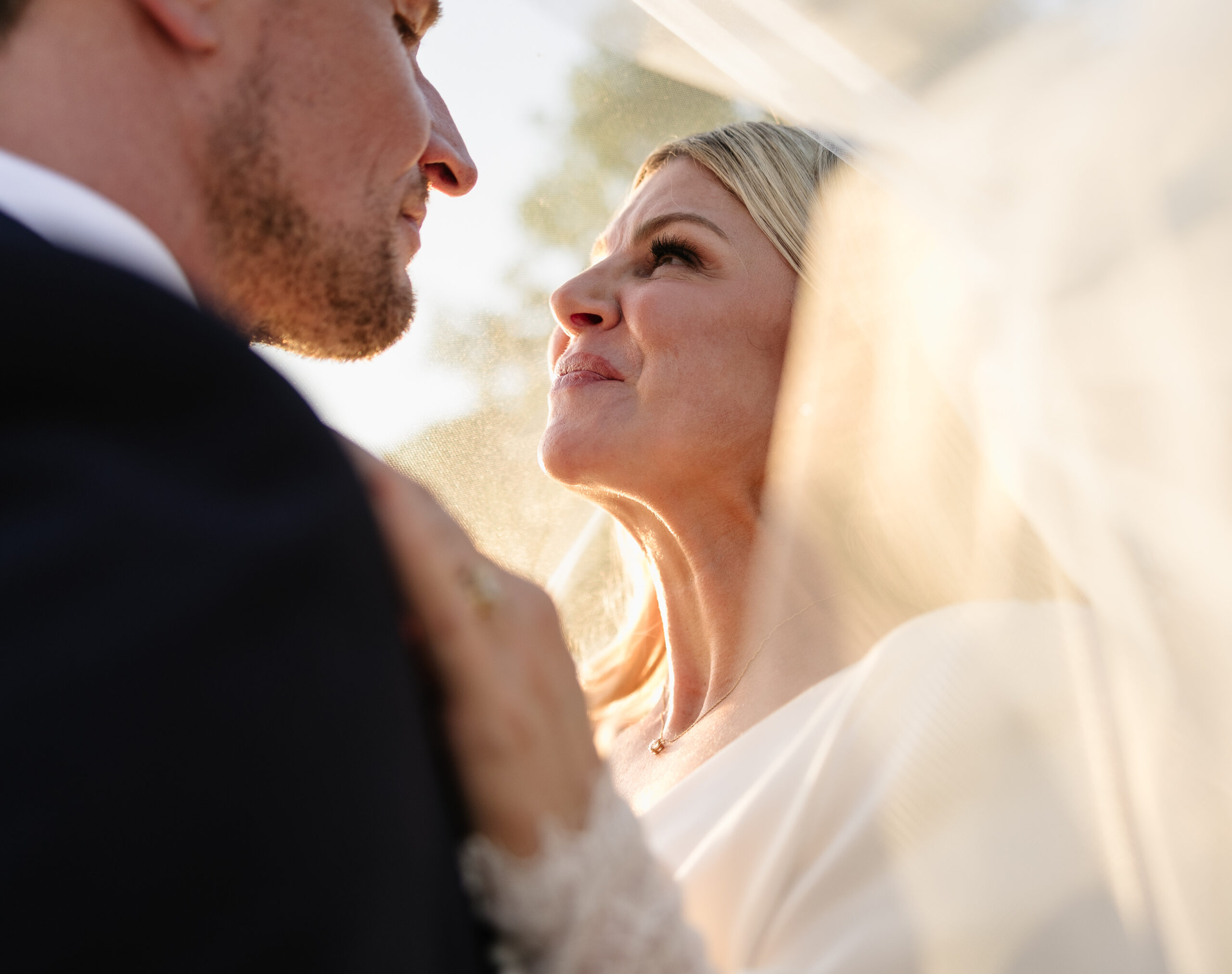 Meshali and her husband lovingly look at one another under her bridal veil